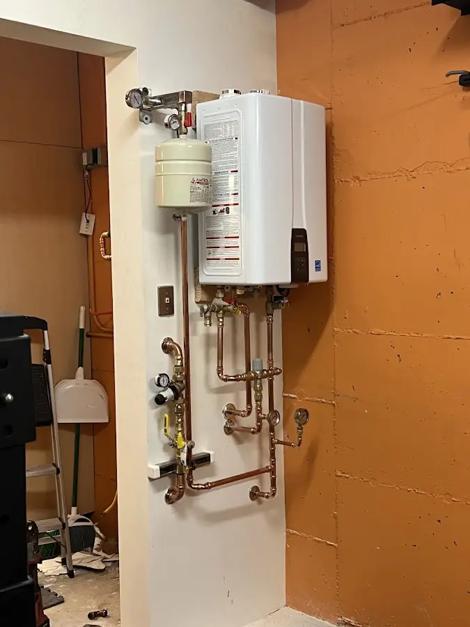 Plumbing technician inspecting water heater connections in Hyde Park
